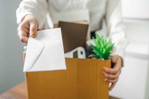 Business woman sending resignation letter and packing Stuff Resign Depress or carrying business cardboard box by desk in office. Change of job or fired from company. (Photo: Charlie's/stock.adobe.com)