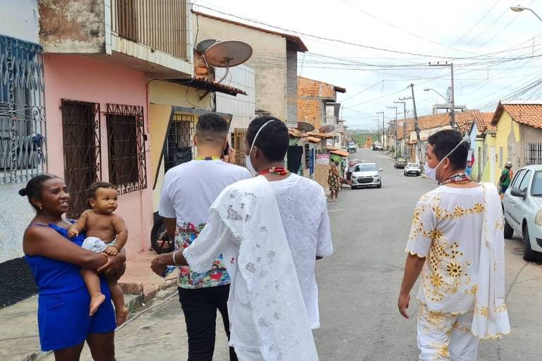 três integrantes do Terreiro Ylé Ashé Oba Yzôo, vestidos de branco, percorrem a rua Thomé de Souza no Bairro Liberdade