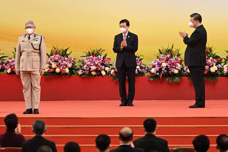 O líder da China, Xi Jinping, à dir., junto ao novo chefe-executivo de Hong Kong, John Lee, ao centro, e ao diretor de imigração do território, Au Ka-wang, no aniversário de 25 anos da devolução da cidade a Pequim