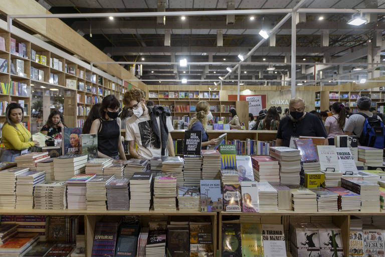 Pessoas observam livros em prateleiras da Bienal do Livro de São Paulo