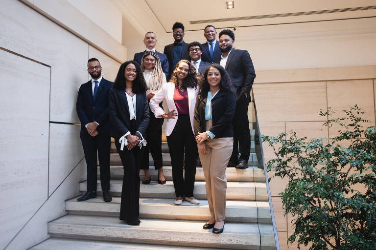 Grupo de advogados negros, homens e mulheres, em uma escada