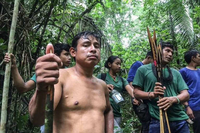 A imagem colorida mostra vários homens indígenas