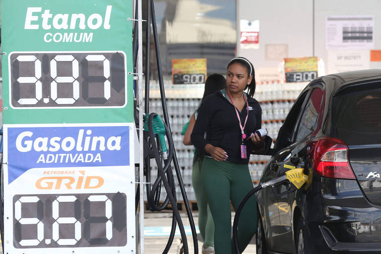 Frentista abastece carro em posto de combustível