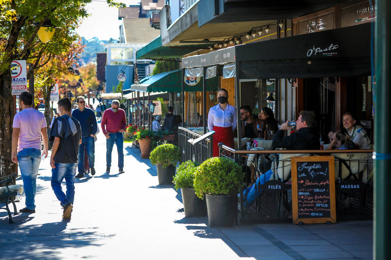 Pedestres caminham em rua da região central de Gramado