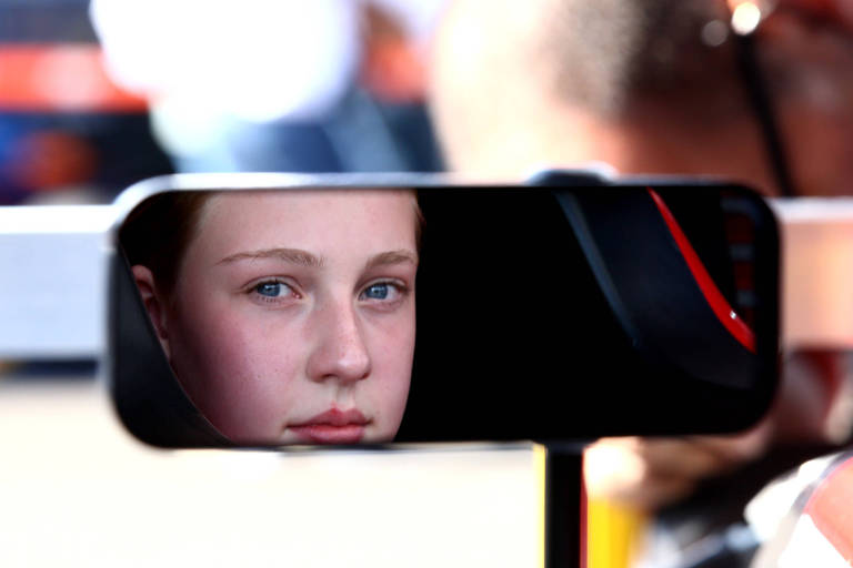 Menina dentro de um carro de corrida