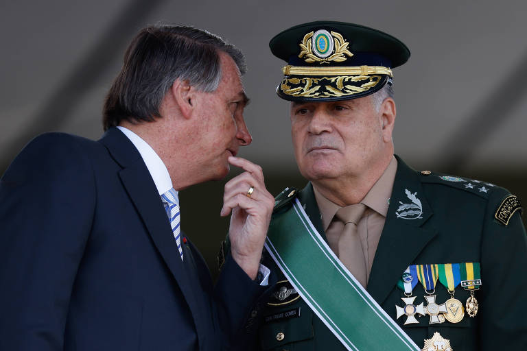 O então presidente Jair Bolsonaro cochicha com o comandante do Exército, general Freire Gomes, em cerimônia do Dia do Soldado em agosto de 2022