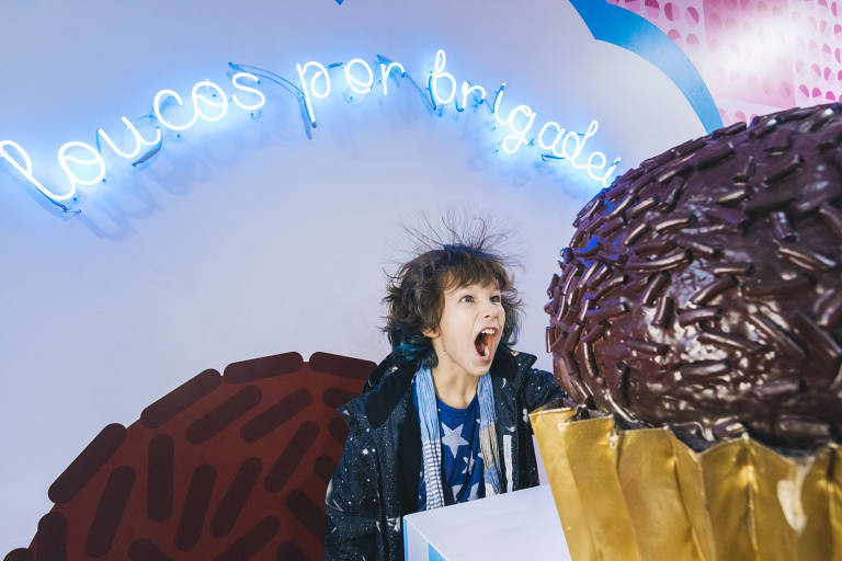 Menina ao lado de brigadeiro gigante