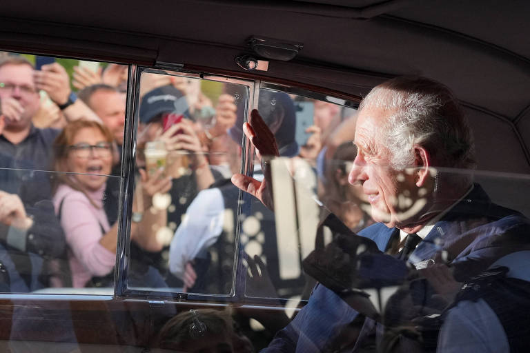 'Deus salve a rainha. Não! O rei!', cantam súditos em local de homenagem a Elizabeth 2ª