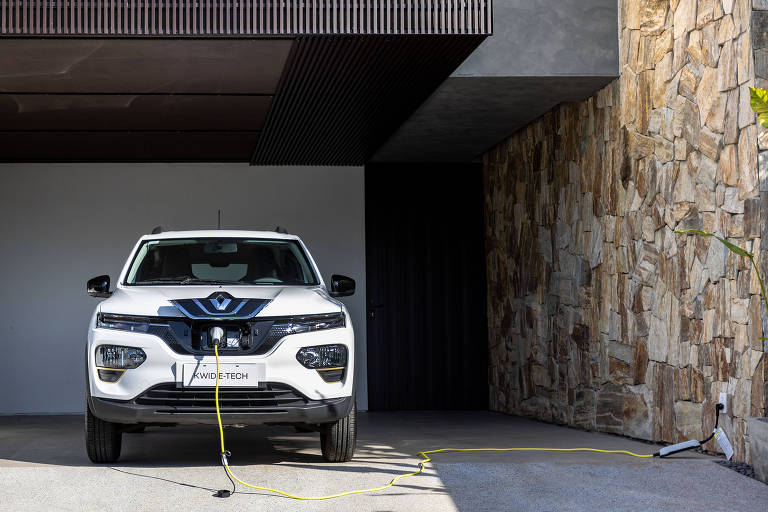 Renault Kwid E-Tech Elétrico ligado por um cabo na tomada de uma garagem