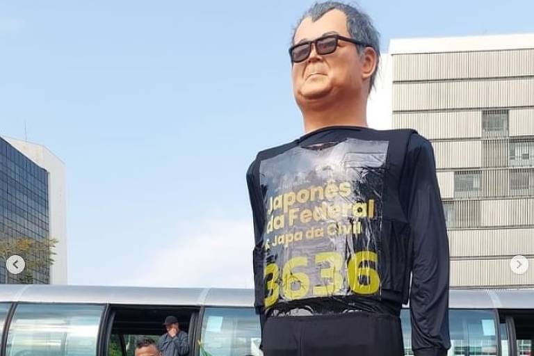 Boneco gigante com o número do candidato com pessoas ao redor