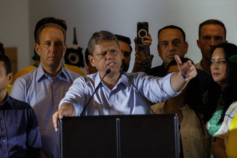 De camisa azul clara de mangas arregaçadas, Tarcísio gesticula com o braço esquerdo