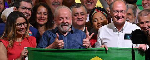 Elected president and vice president for the leftist Workers Party (PT) Luiz Inacio Lula da Silva (C) and Geraldo Alckmin (R) celebrate after winning the presidential run-off election, in Sao Paulo, Brazil, on October 30, 2022. - Brazil's veteran leftist Luiz Inacio Lula da Silva was elected president Sunday by a hair's breadth, beating his far-right rival in a down-to-the-wire poll that split the country in two, election officials said. (Photo by NELSON ALMEIDA / AFP)