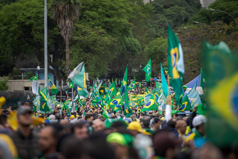 Com bandeiras do Brasil e camisetas verde e amarelo, apoiadores de Jair Bolsonaro protestam e pedem intervenção militar em novembro de 2022 