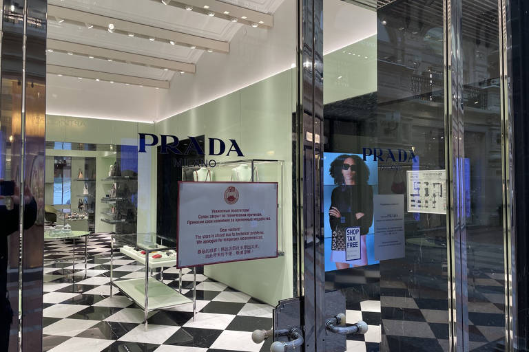 Vitrine de loja da marca italiana Prada com aviso de fechamento no shopping moscovita GUM