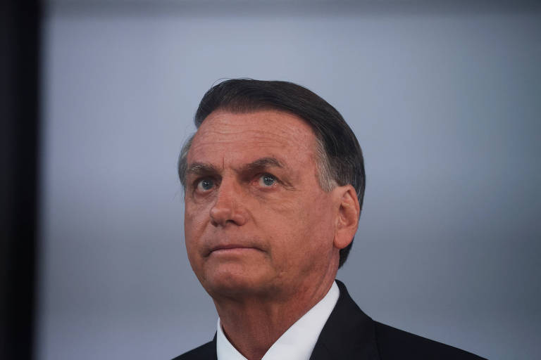 Bolsonaro, um homem branco, cabelos castanhos e olhos claros, com semblante sério