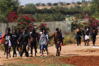 Migrants hold sticks during clashes outside Pournara refugee camp on the outskirts of Nicosia,