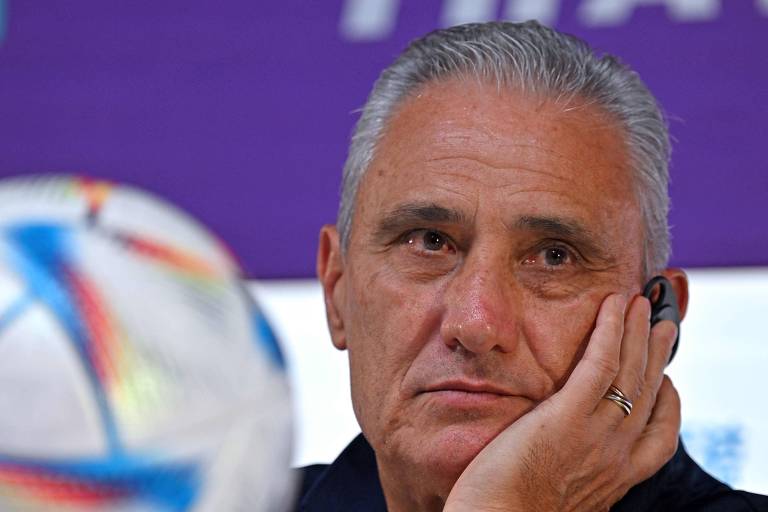 O técnico da seleção brasileira, Tite, com o rosto apoiado na mão esquerda durante entrevista no Centro de Convenções do Qatar na véspera da estreia da seleção na Copa do Mundo de 2022