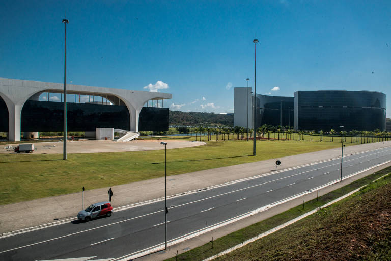 A foto mostra a Cidade Administrativa, formada por três prédios construídos com projeto do arquiteto Oscar Niemeyer. No primeiro plano, a rodovia MG-050, que dá acesso ao local.
