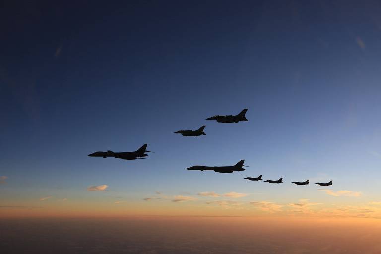 Caças japoneses escoltam dois bombardeiros estratégicos americanos B-1B sobre a ilha de Kyushu