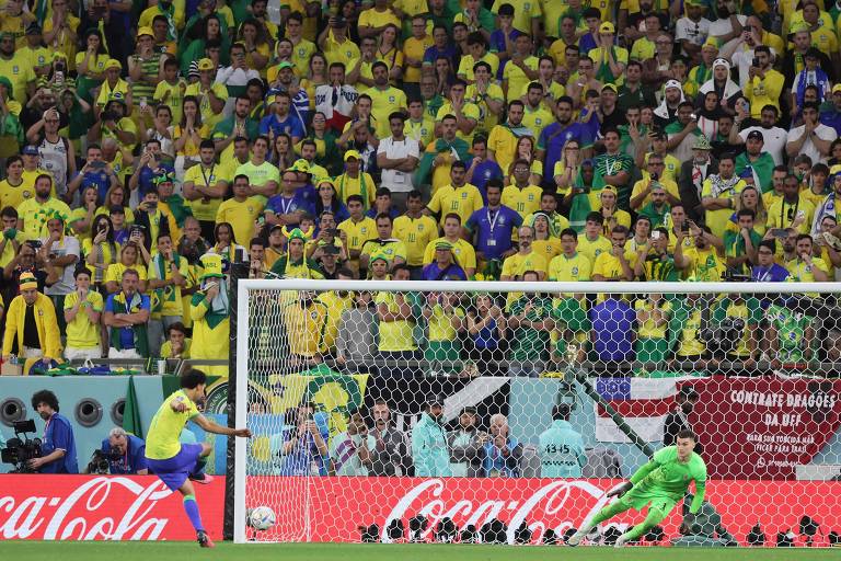 Marquinhos bate o pênalti no canto esquerdo, na direção da trave, na disputa de penalidades entre Brasil e Croácia no estádio Cidade da Educação, no Qatar; o goleiro Livakovic pula para o lado errado