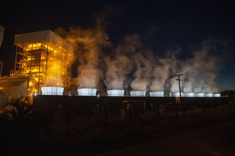 Chaminés de de usinas de carvão mineral despejam fumaças tóxicas em um cenário escuro com pouca iluminação