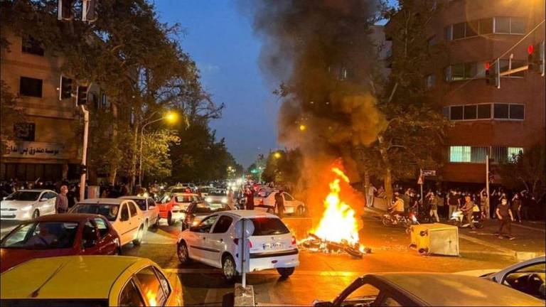 Carros desviam de uma fogueira no meio de uma avenida