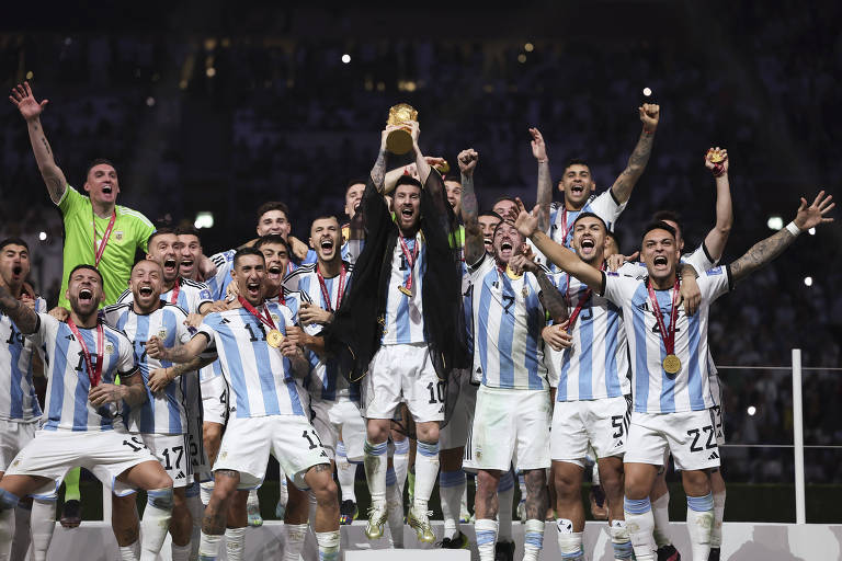 Rodeado de colegas de seleção, Messi ergue a Taça Fifa no estádio de Lusail depois de a Argentina ganhar a Copa do Mundo no Qatar