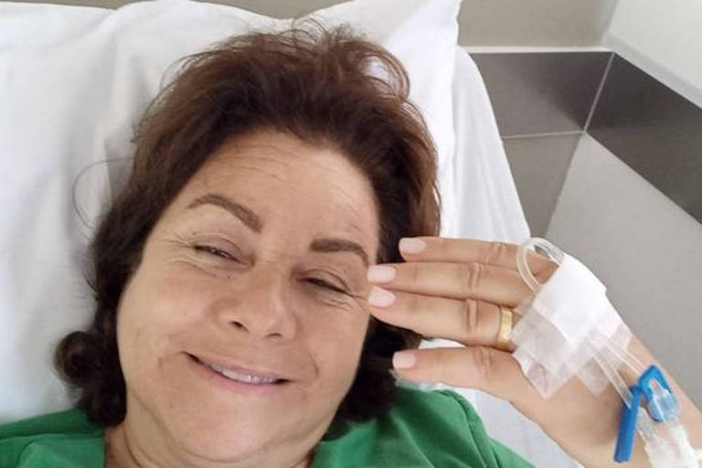 Mulher mostrando mão com tubo de acesso venoso