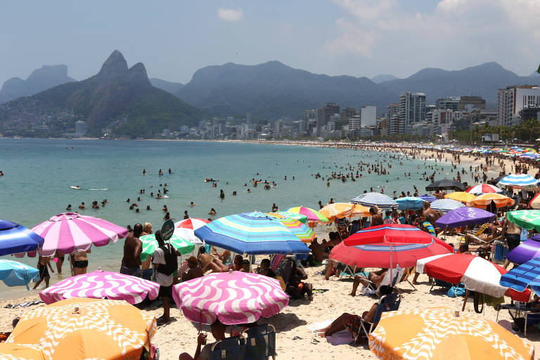 Banhistas com guarda-sóis na praia 