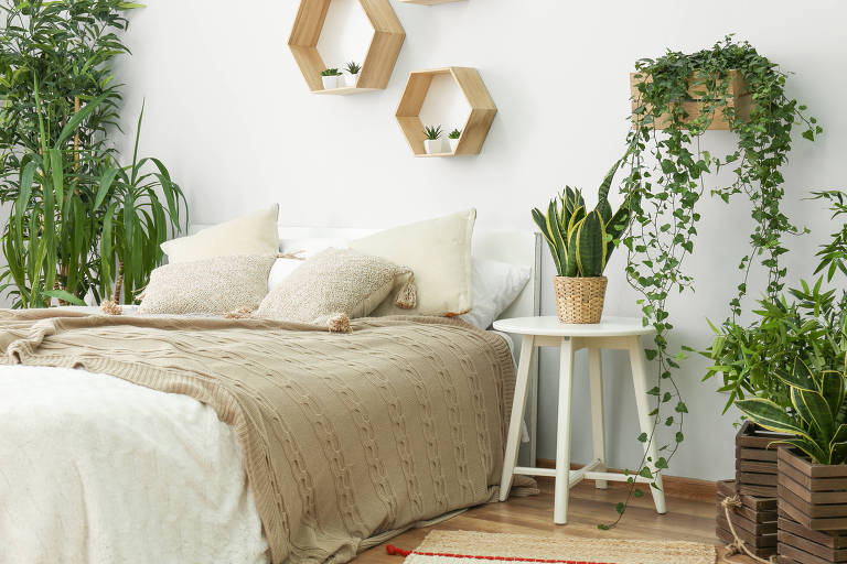 Quarto branco com plantas em volta da cama