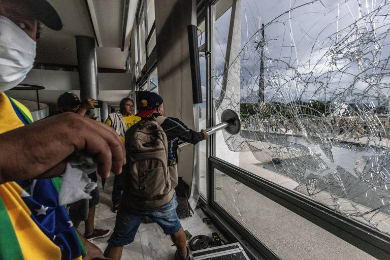 Invasor bolsonarista quebra janela do Palácio do Planalto durante o ataque de 8 de janeiro de 2023