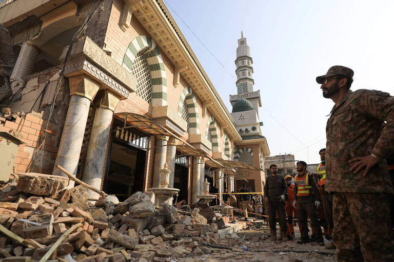 Soldado e socorristas avaliam os estragos após atentado suicida destruir mesquita em Peshawar, no Paquistão