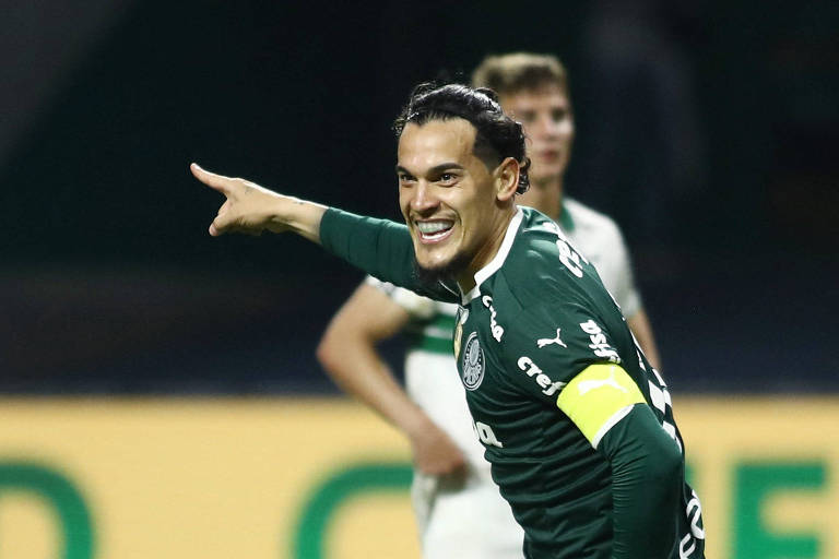 Sorrindo, apontando com o dedo indicador da mão direita para a frente e usando tarja amarela de capitão do tome sobre a camisa verde escura, Gustavo Gómez comemora gol contra o Coritiba no Allianz Parque, pelo Campeonato Brasileiro de 2022