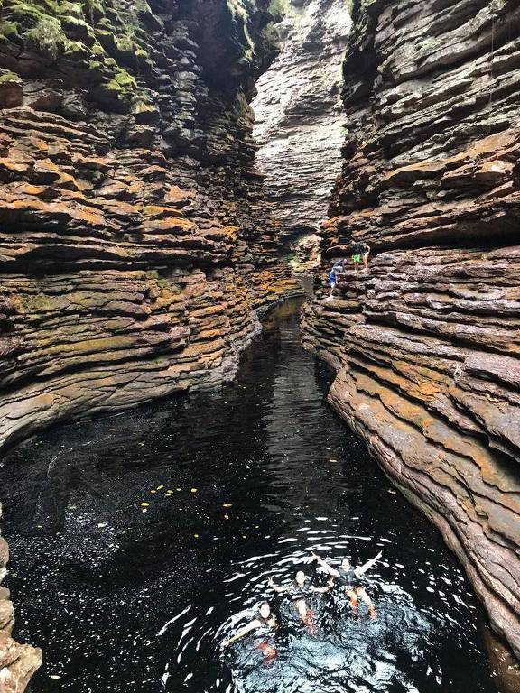 foto de paredão de pedras e rio, com turistas