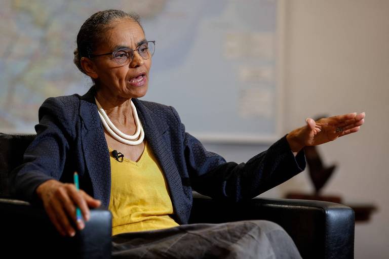 Usando blazer escuro, blusa amarela e colar branco, a ministra Marina Silva gesticula enquanto fala