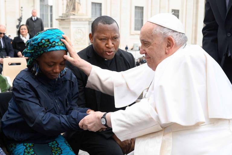 Papa Francisco abençoa mulher nigeriana que foi vítima do grupo islâmico Boko Haram durante sua audiência semanal na praça São Pedro, no Vaticano