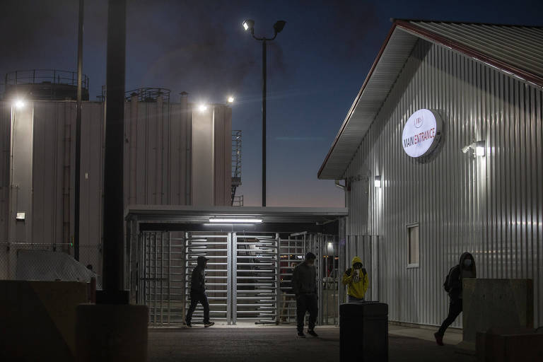 jovens entram em uma fábrica à noite