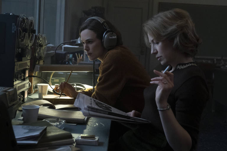 Keira Knightley e Carrie Coon, sentadas à mesa e analisando papéis, em cena de "O Estrangulador de Boston"