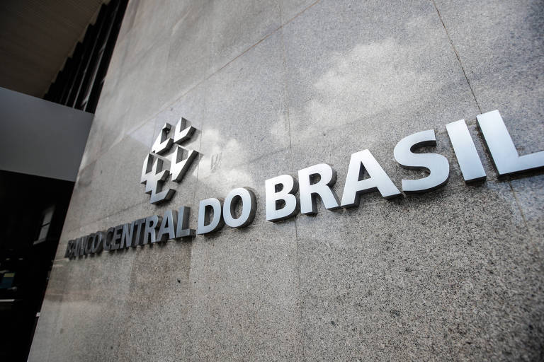 A imagem mostra a entrada do Banco Central do Brasil com o nome da instituição em letras destacadas na parede de concreto.