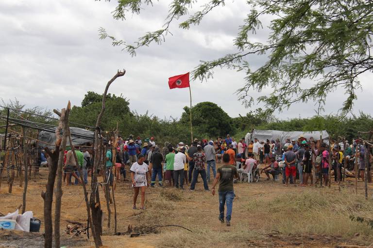 Foto mostra bandeira do MST e trabalhadores ao redor