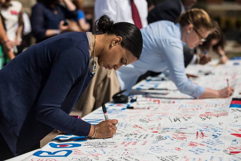 Mulher assina homenagem em memorial às vítimas do atentado na maratona de Boston, nos EUA