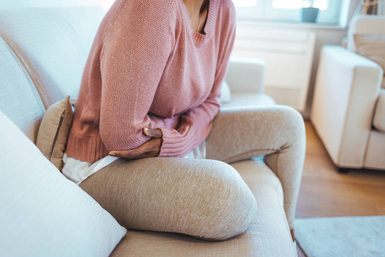 Foto recortada de uma jovem atraente deitada na cama e sofrendo de dores menstruais em casa. Ai! Minha barriga! Mulher com dor menstrual