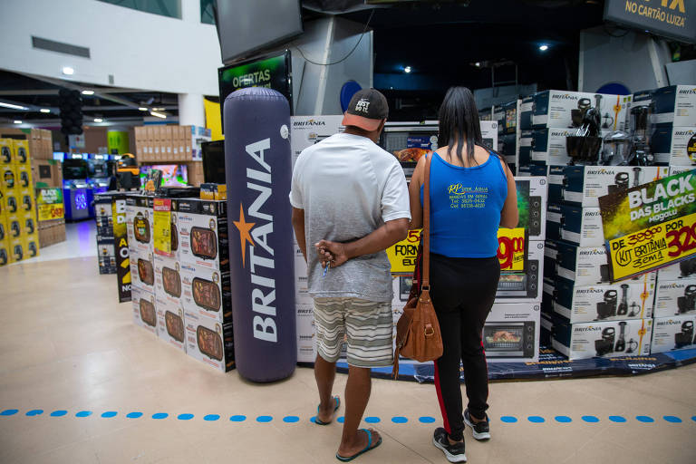 homem e mulher diante de eletrodomésticos em uma loja