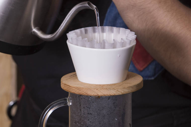 Café sendo coado em um coador branco
