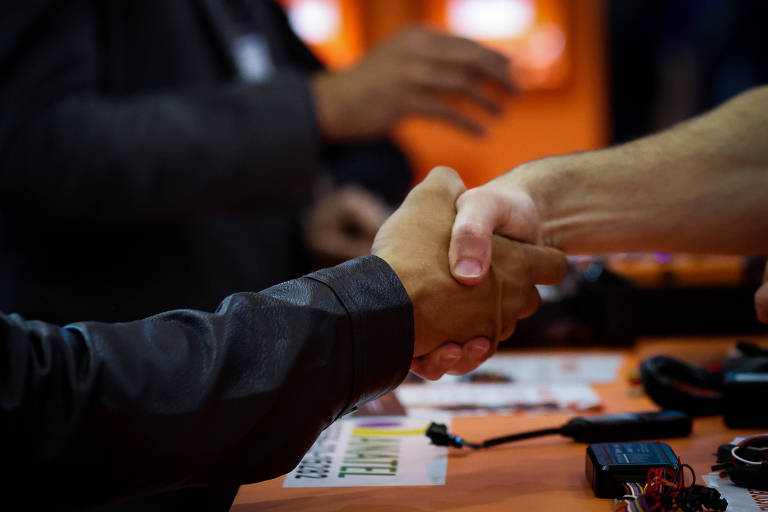 mãos de um homem branco e outro negro se cumprimentam