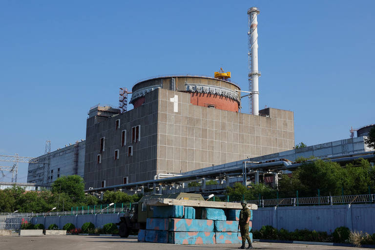 Militar russo faz guarda em frente a posto de checagem próximo à usina nuclear de Zaporíjia, na Ucrânia