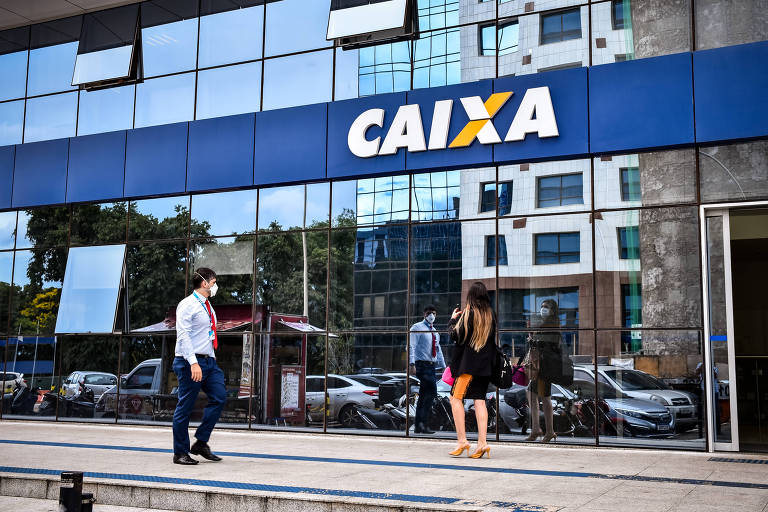 Imagem mostra fachada espelhada do prédio da Caixa Econômica Federal em Brasília (DF). Na foto, um homem de terno e gravata e uma mulher de vestido estão em frente ao prédio