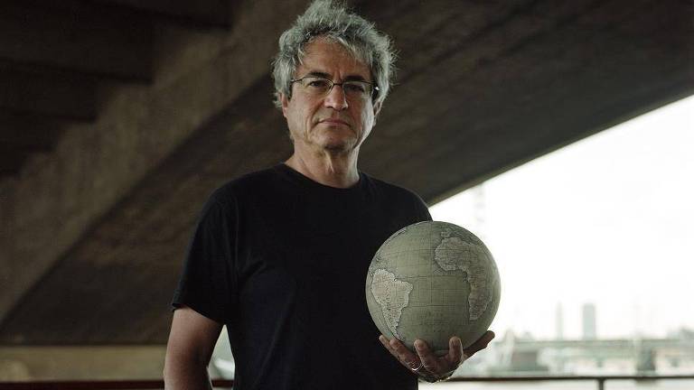 Físico Carlo Rovelli segura um globo terrestre em uma das mãos