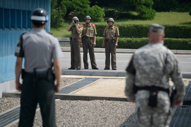 Soldado da Coreia do Norte tira fotos na direção de militares da vizinha Coreia do Sul na região da zona desmilitarizada na península 