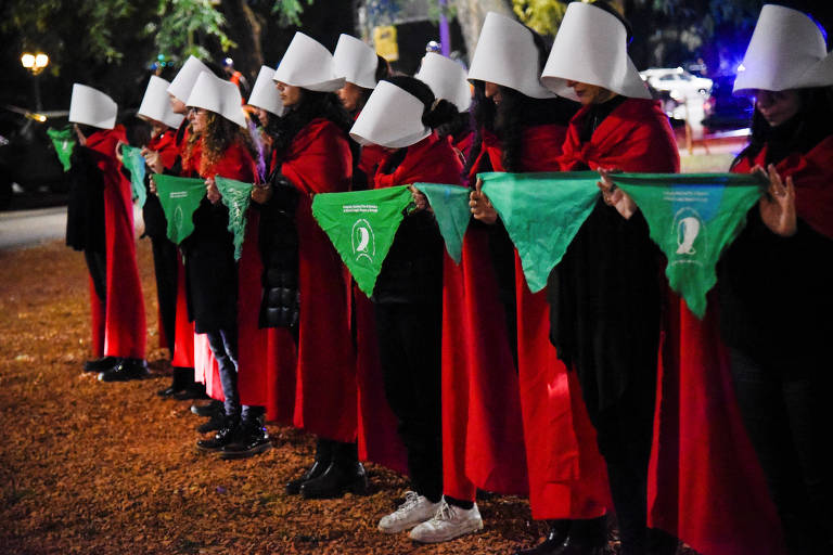 Manifestantes em defesa da legalização do aborto protestam nos arredores da embaixada dos EUA em Buenos Aires, na Argentina, vestidas como personagens de 'O Conto da Aia'